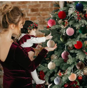 Gezellige scène van moeder en kind die de boom versieren met fluwelen kerstbalornamenten