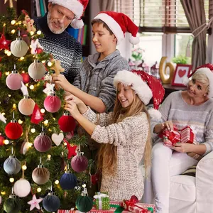 Kleurrijke met stof beklede kerstbalversieringen die een boom in een gezinsscène versieren