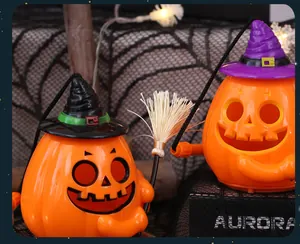 Detail of glowing Halloween pumpkin buckets with witch hats and broom prop.