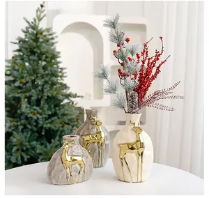Detailansicht der Weihnachts-Keramikvasen mit goldenen Rentieren und Zweigen
