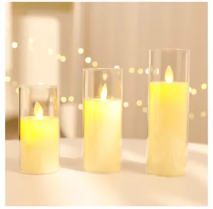 Primo piano di tre candele LED in cilindri di vetro con luci calde e tremolanti