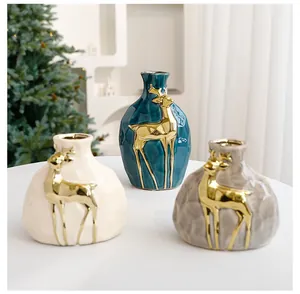 Detailansicht von drei Weihnachts-Keramikvasen mit goldenen Hirschen und strukturierter Optik