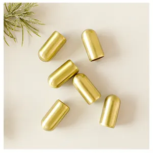 Detailed close-up of six elegant golden metallic Christmas bell ornaments on white.