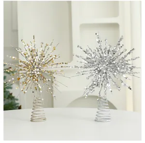 Detail view of champagne and silver glitter starburst Christmas decorations on a white table