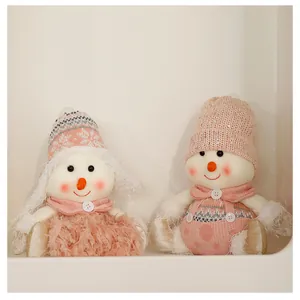 Detalle de dos adorables muñecos de nieve rosa con gorros de punto y lentejuelas brillantes