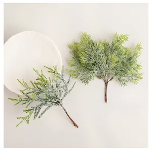 Detailed view of artificial green cypress branches with frosted snow for DIY home decor