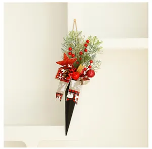Detail of a Christmas hanging ornament with pine needles, red berries and a plaid ribbon.