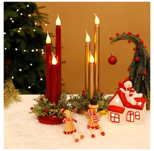 Nahaufnahme von roten und goldenen flammenlosen LED-Weihnachtskerzen in festlichem Dekor