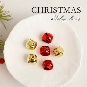 Feestelijke set van rode en gouden kerstbelletjes op een getextureerd wit bord