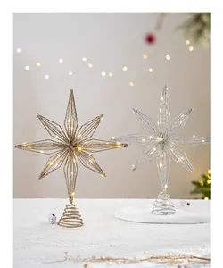 Close-up detail of gold and silver glittered Christmas tree star toppers with LED lights
