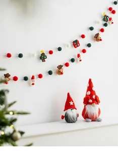 Guirlande de Noël en feutre de laine avec figurines de gnomes sur une étagère blanche
