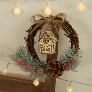 Rustic Christmas grapevine wreath decorated with a glowing wooden house and red berries