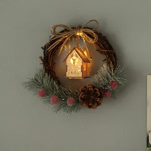 Festive Christmas wreath featuring a lighted wooden house with pinecone and red berries