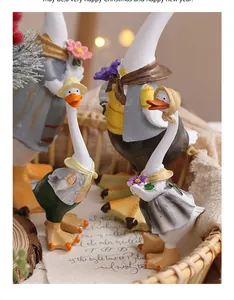 Détail de figurines de canards en résine de style rustique dans un panier de Noël