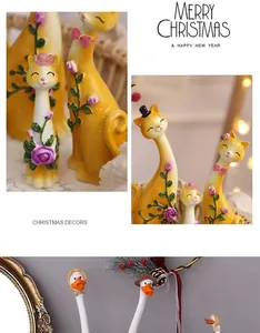 Détail de figurines de chat et canard en résine avec décorations festives de Noël mignonnes.