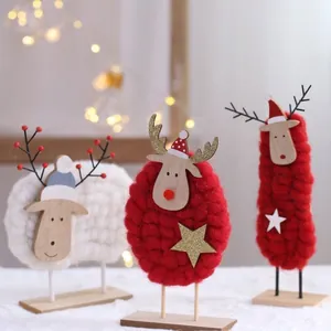 Handgemaakte kerst rendier tafelornamenten met rode en witte garen lichamen en houten voetstukken