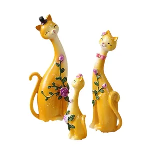Lot de trois figurines de chat jaune à long cou avec décorations de roses en relief