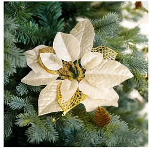 Gros plan d'un poinsettia artificiel champagne avec paillettes dorées sur un sapin