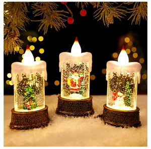 Detailopname van drie verlichte kerstwaterkaarsen met kerstman, sneeuwman en kerstboom