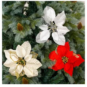 Gros plan de poinsettias en tissu pailleté rouge et argenté sur un sapin de Noël vert