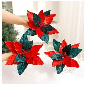 Detailed macro view of handmade red and green glittery velvet poinsettia flowers.