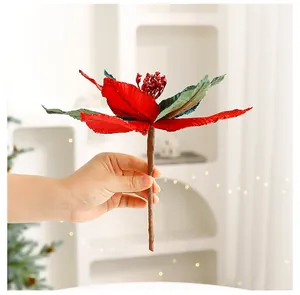 Hand holding a detailed red velvet artificial Poinsettia Christmas flower decoration