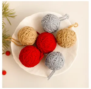 Detailed view of handmade colorful Christmas yarn ball ornaments on a rustic white plate