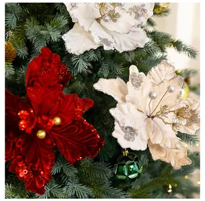 Détail de fleurs de Noël en velours avec des paillettes brillantes sur des branches.