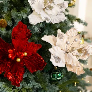 Fleurs de poinsettia de Noël en velours de luxe avec paillettes brillantes sur un sapin.