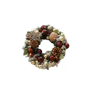 Exquisita corona de Navidad con piñas, adornos y cartel dorado de Merry Christmas