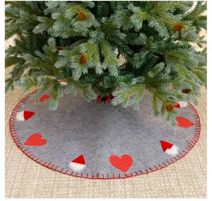 Large grey felt Christmas tree skirt with red heart and Santa hat patterns detail.