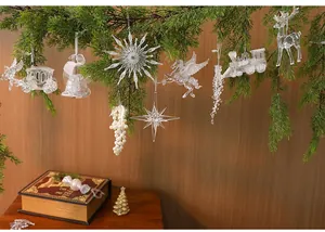 Vista detallada de adornos navideños de acrílico transparente en ramas de pino