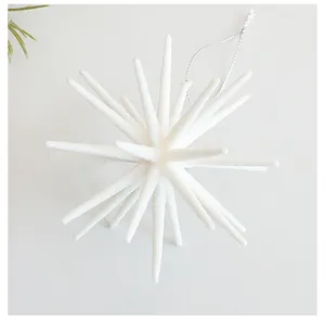 Close-up of a white frosted starburst Christmas ornament with silver hanging string