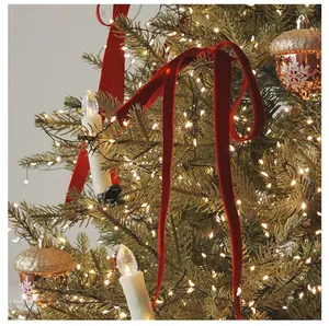 Primo piano dettagliato di eleganti nastri di velluto rosso che decorano un albero di Natale