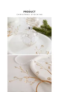 Close-up van witte en gouden kerstbal ornament en decoratieve takken met kralen.