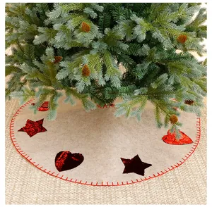 Detail view of a beige felt Christmas tree skirt with red sequin hearts and star patterns.