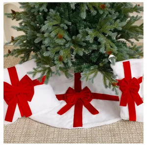 Detailed view of plush white Christmas tree skirt with red velvet bows decoration