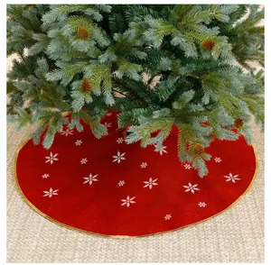 Detailed view of red Christmas tree skirt with white snowflake embroidery and gold trim