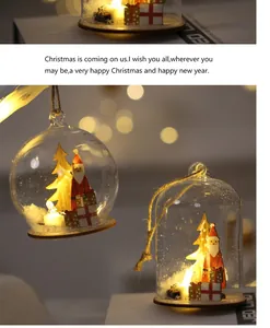 Vista detallada de adornos de cristal navideños con Papá Noel y cálidas luces LED suaves