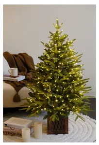Close-up of warm LED copper wire fairy lights on a festive Christmas tree in a cozy room.