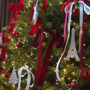 Nastri natalizi in velluto e ornamenti glitterati su un albero festivo illuminato
