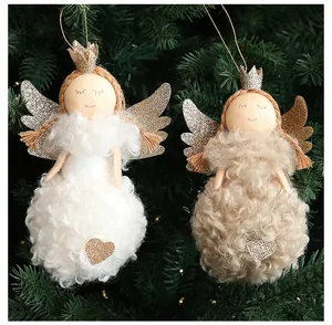 Detailed view of two plush white and beige Christmas angel doll ornaments hanging on a tree