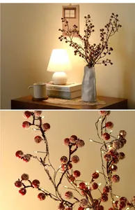 Close-up of LED red berry string lights with snowy texture for festive Christmas decor