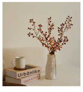 Detail showing warm LED fairy lights entwined in festive red berry branches for home decor