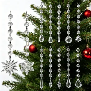 Collectie van diverse heldere kristallen kerstversieringen hangend aan een versierde tak