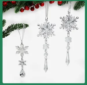 Vue détaillée de suspensions flocons de neige en cristal avec décor de verdure festive