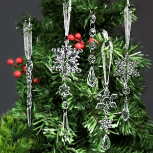 Collection of clear crystal snowflake and icicle ornaments hanging on a festive Christmas tree.