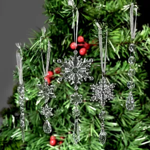 Set of clear crystal Christmas snowflake and icicle ornaments hanging on a green tree.