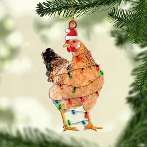 Vista detallada de un adorno navideño de pollo colgado en una rama de pino verde
