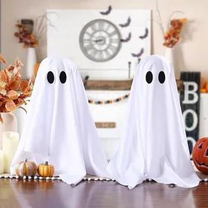 Primo piano di due fantasmi di Halloween in tessuto bianco con calda illuminazione d'atmosfera